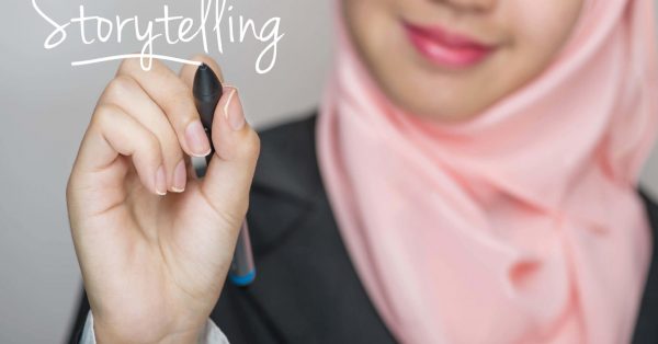 Business woman writing text : Storytelling over gray background